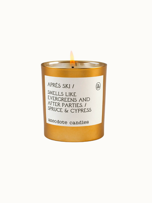 Anecdote Candles Aprés Ski Candle in gold tumbler with fragrance notes of spruce and cypress, a perfect holiday gift
